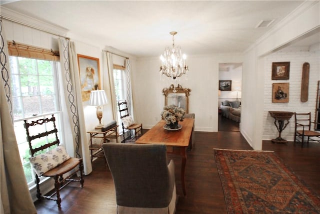 dining space featuring crown molding, dark wood-type flooring, and a chandelier