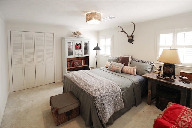 bedroom with multiple windows, light carpet, and a closet