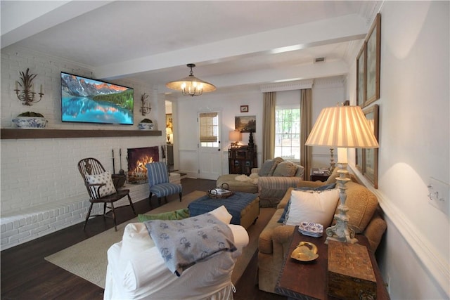 living room with a fireplace, beamed ceiling, dark hardwood / wood-style floors, and a notable chandelier