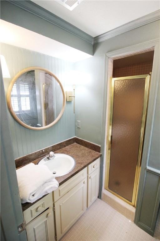 bathroom with tile patterned flooring, vanity, a shower with door, and ornamental molding