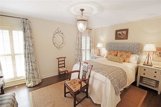 bedroom with dark hardwood / wood-style flooring and multiple windows