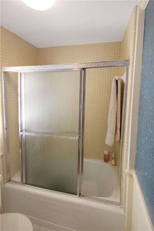 bathroom with tile patterned flooring, enclosed tub / shower combo, and toilet