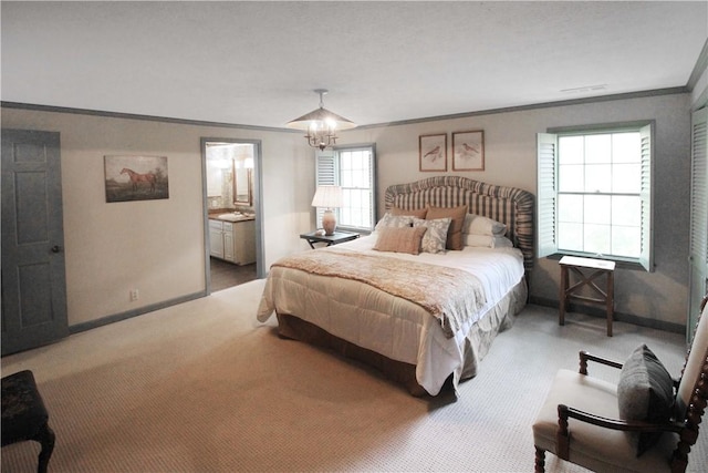 carpeted bedroom featuring ensuite bathroom, an inviting chandelier, and ornamental molding