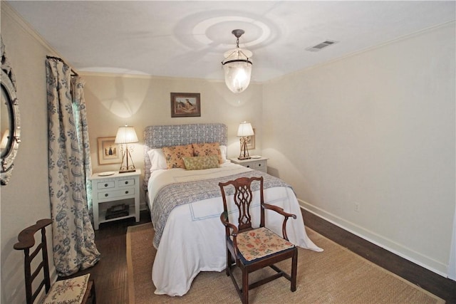 bedroom with dark hardwood / wood-style flooring and ornamental molding