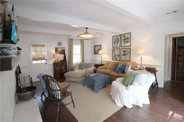 living room featuring a fireplace, beam ceiling, dark hardwood / wood-style flooring, and an inviting chandelier