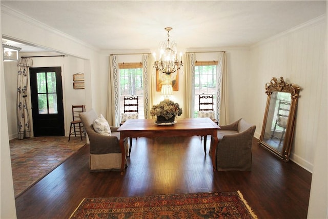 unfurnished dining area with plenty of natural light, dark hardwood / wood-style floors, ornamental molding, and an inviting chandelier