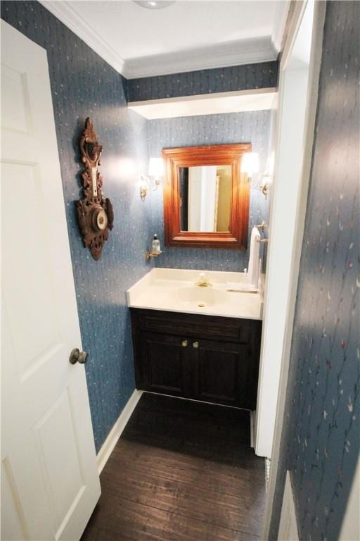 bathroom featuring vanity, wood-type flooring, and ornamental molding