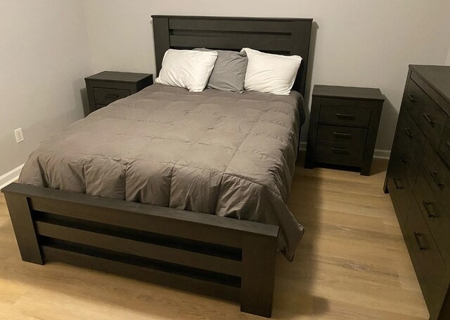 bedroom with baseboards and light wood finished floors