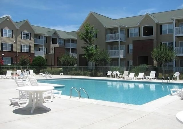 view of swimming pool with a patio and fence