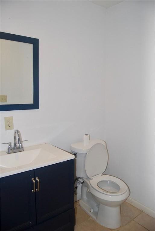bathroom featuring toilet, tile patterned floors, vanity, and baseboards