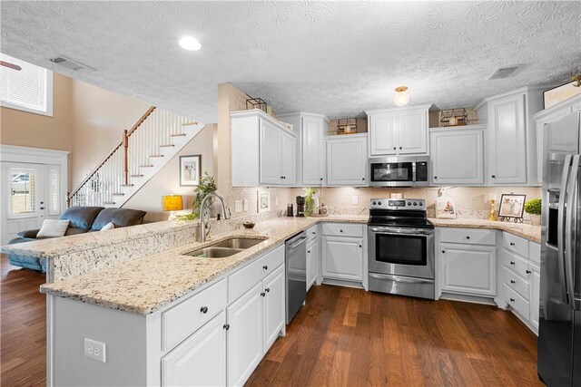 304 Marthas Ct, Opelika, AL 36801 - kitchen with stainless steel appliances, a sink, white cabinets, dark wood finished floors, and recessed lighting