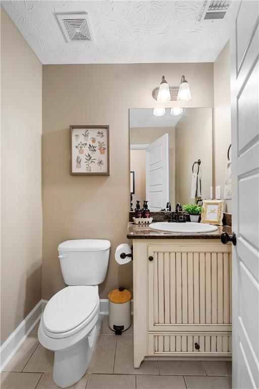 304 Marthas Ct, Opelika, AL 36801 - half bath featuring toilet, tile patterned floors, baseboards, and a textured ceiling