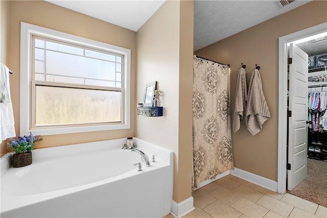 304 Marthas Ct, Opelika, AL 36801 - bathroom with baseboards, a bath, tile patterned floors, a spacious closet, and curtained shower