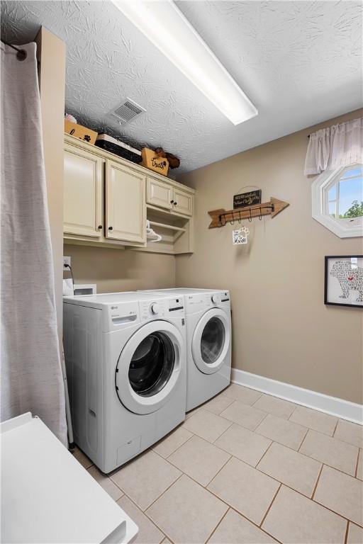 304 Marthas Ct, Opelika, AL 36801 - laundry room featuring cabinet space, washing machine and clothes dryer, baseboards, light tile patterned floors, and a textured ceiling