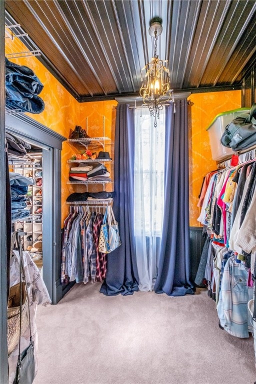 spacious closet with an inviting chandelier and carpet