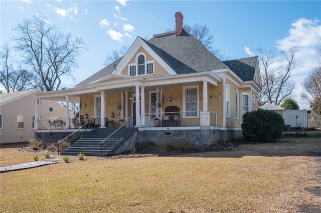 farmhouse inspired home with a porch, a shingled roof, and a front lawn