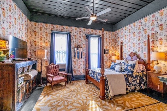 bedroom with a ceiling fan and wallpapered walls