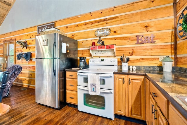 1515 County Road 63, Tuskegee, AL 36083 - kitchen with double oven range, freestanding refrigerator, dark countertops, wooden walls, and dark wood-style flooring
