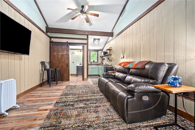 1515 County Road 63, Tuskegee, AL 36083 - living room with radiator heating unit, wood walls, wood finished floors, a ceiling fan, and a barn door