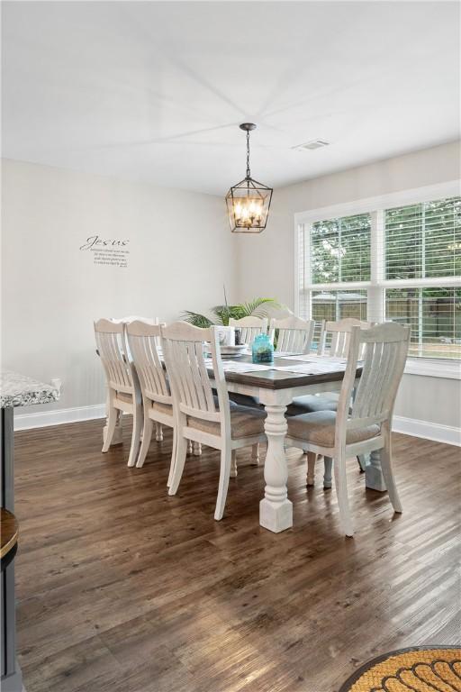 dining area featuring baseboards, wood finished floors, and a chandelier