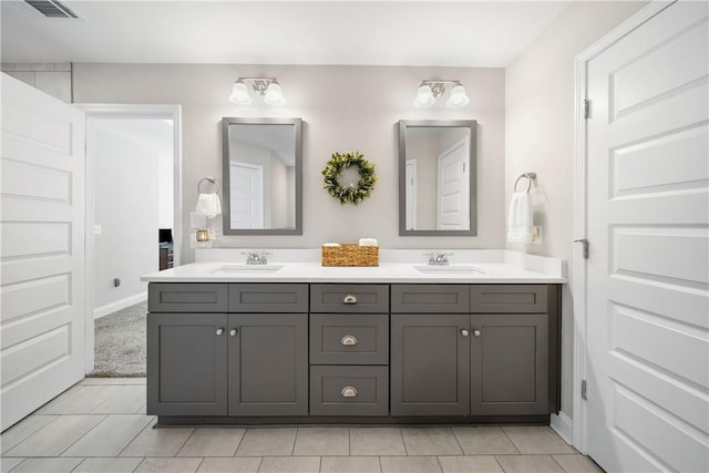 bathroom featuring double vanity, tile patterned flooring, and baseboards