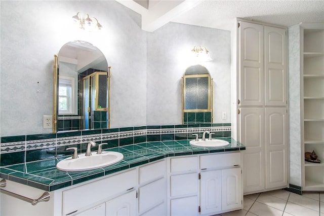 bathroom with walk in shower, tasteful backsplash, tile patterned flooring, a textured ceiling, and vanity