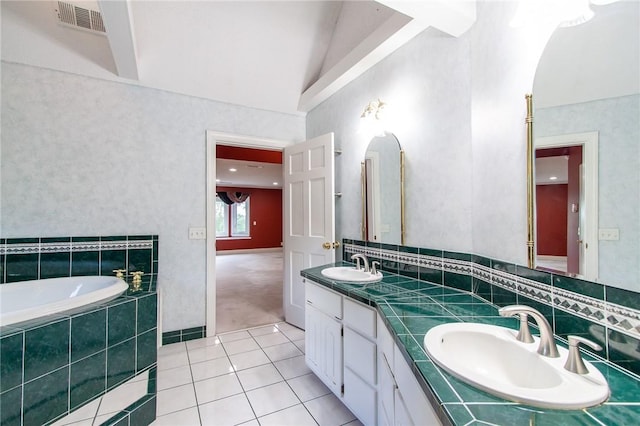 bathroom featuring tile patterned floors, vanity, a relaxing tiled tub, and lofted ceiling