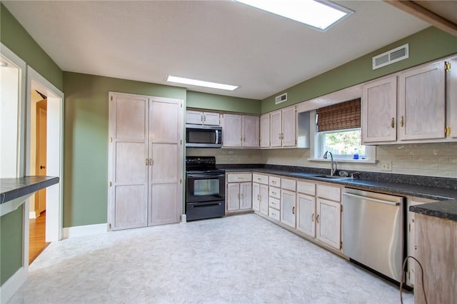 kitchen featuring light brown cabinets, stainless steel appliances, tasteful backsplash, and sink