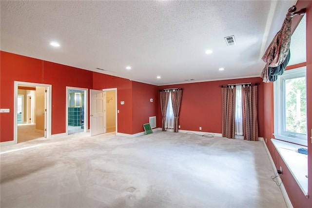 unfurnished room with a textured ceiling and light colored carpet