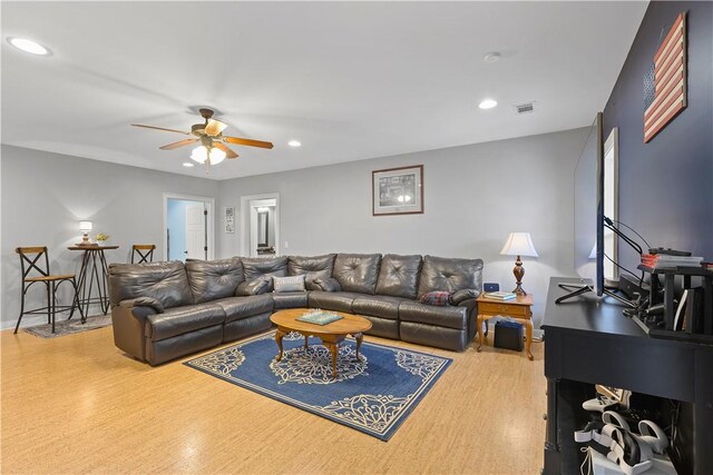 living room featuring wood-type flooring and ceiling fan