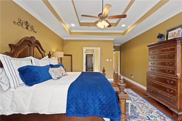 bedroom featuring a raised ceiling, ornamental molding, ceiling fan, and dark hardwood / wood-style flooring