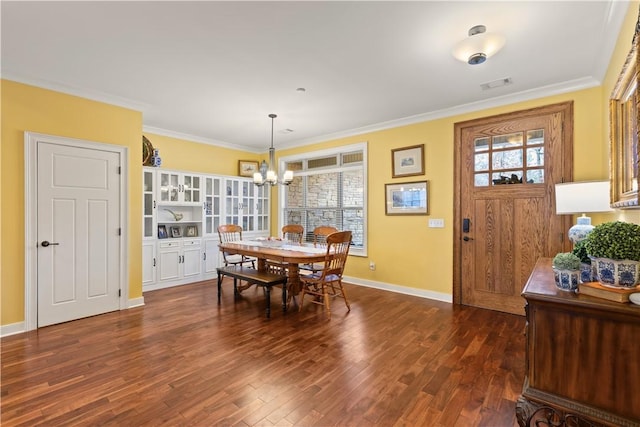 dining room featuring crown molding, dark hardwood / wood-style floors, and a notable chandelier