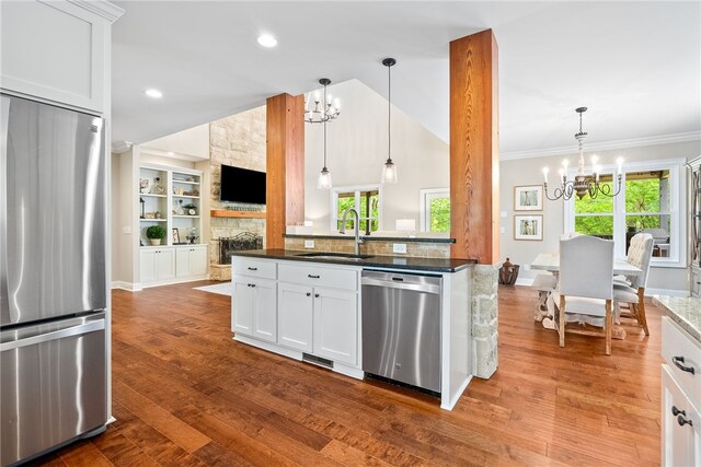 1462 Turn Lake Dr, Auburn, AL 36830 - kitchen featuring stainless steel appliances, a chandelier, open floor plan, a fireplace, and white cabinetry