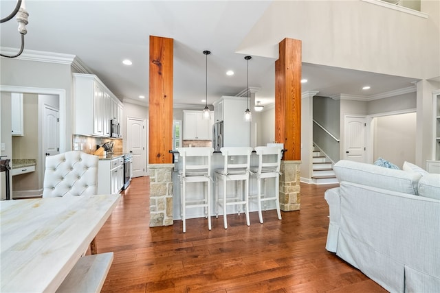 1462 Turn Lake Dr, Auburn, AL 36830 - kitchen with ornamental molding, appliances with stainless steel finishes, a kitchen bar, wood finished floors, and recessed lighting