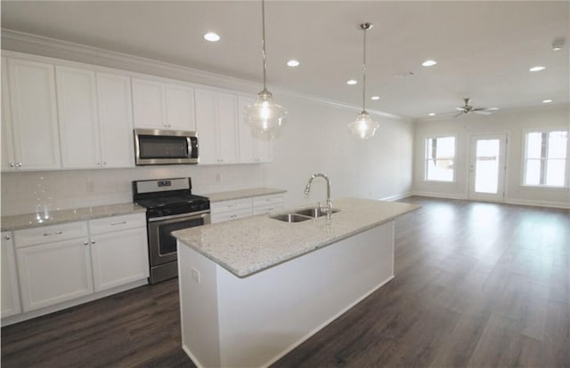 kitchen with sink, decorative light fixtures, an island with sink, stainless steel appliances, and white cabinets