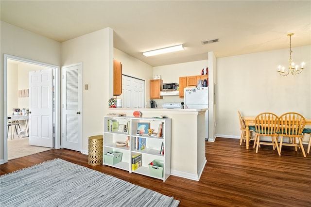 kitchen with white fridge, range, hardwood / wood-style floors, a chandelier, and pendant lighting