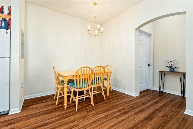 dining room with dark hardwood / wood-style flooring and a notable chandelier