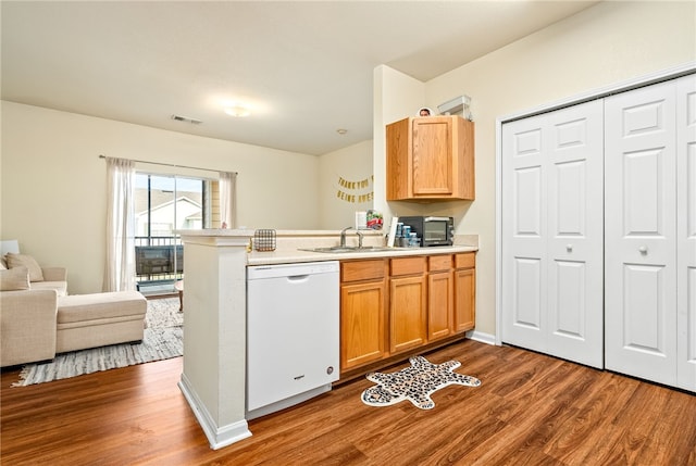 kitchen featuring kitchen peninsula, sink, white dishwasher, and hardwood / wood-style flooring