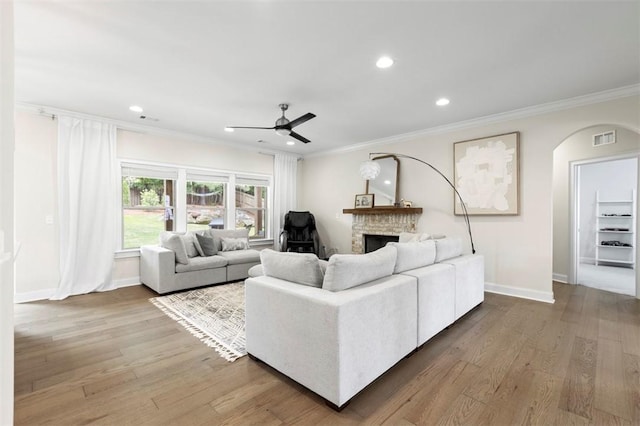 484 Bennington Ct, Auburn, AL 36830 - living area featuring crown molding, a brick fireplace, ceiling fan, wood finished floors, and arched walkways