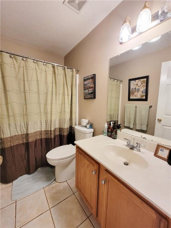2580 Lee Road 148, Opelika, AL 36804 - bathroom with a textured ceiling, tile patterned flooring, vanity, and toilet