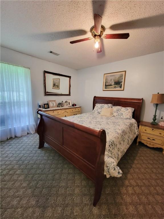 2580 Lee Road 148, Opelika, AL 36804 - bedroom with dark carpet, a textured ceiling, and ceiling fan