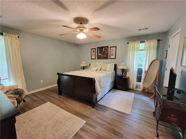 2580 Lee Road 148, Opelika, AL 36804 - bedroom featuring wood finished floors, a textured ceiling, ceiling fan, and baseboards