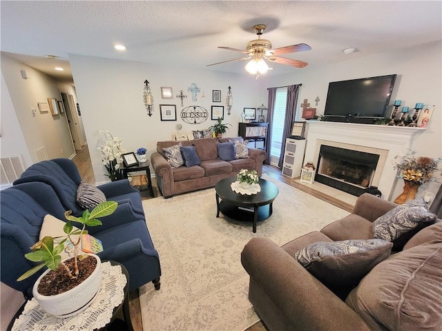 2580 Lee Road 148, Opelika, AL 36804 - living room featuring a ceiling fan, a tiled fireplace, a textured ceiling, and recessed lighting