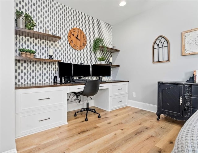 home office featuring built in desk and light hardwood / wood-style floors