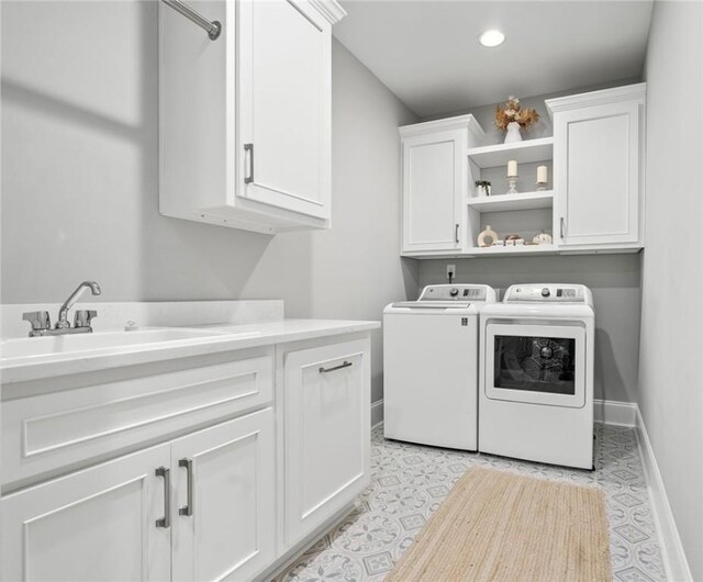 laundry area featuring cabinets, independent washer and dryer, and sink