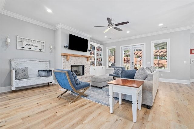 living room featuring ceiling fan, french doors, built in features, light hardwood / wood-style flooring, and a fireplace