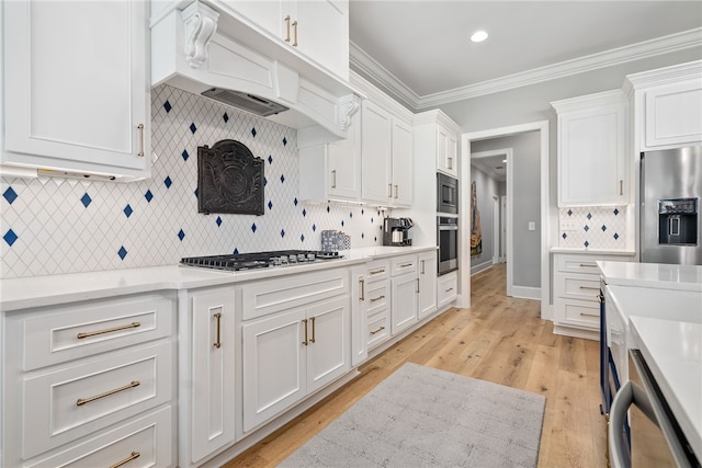 kitchen featuring white cabinets, stainless steel appliances, and ornamental molding