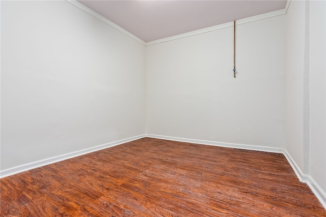 empty room featuring wood-type flooring and crown molding