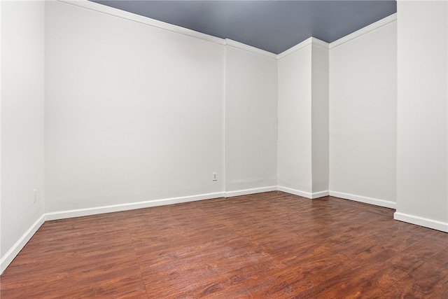 empty room with crown molding and dark hardwood / wood-style floors