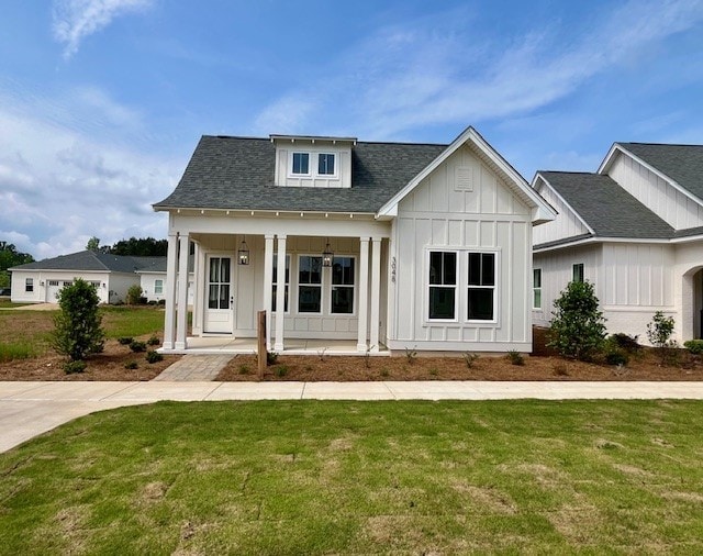 modern farmhouse style home with a porch and a front yard